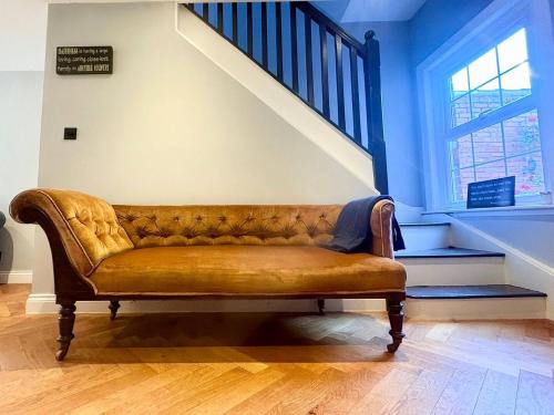 a brown couch in a room with a staircase at Central 2br I Pets I Parking in Hereford