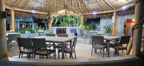 a restaurant with tables and chairs and a roof at Casa Condo Diamante, Nueva Vallarta in Nuevo Vallarta 