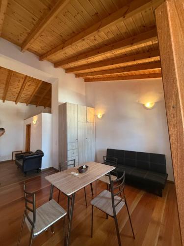 a living room with a table and chairs and a couch at Ikarian Loft 1 in Évdhilos