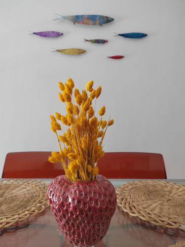 a red vase with flowers in it on a table at The cozy seaside apartment in Nafpaktos