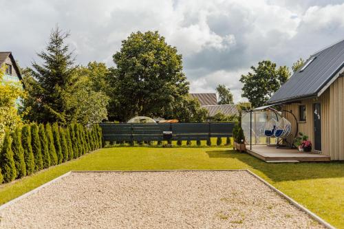 a backyard of a house with a fence at Tiny house Sigulda in Sigulda
