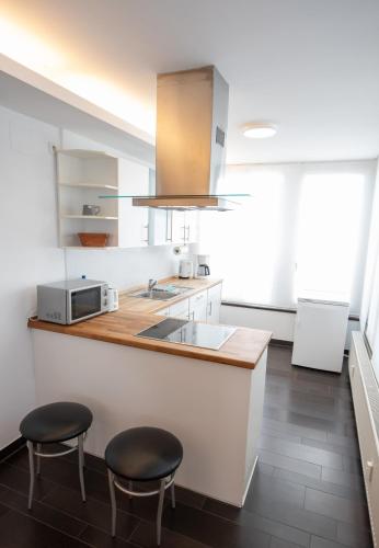 a kitchen with two stools and a counter with a sink at "Cooles Ferienhaus!" - im Coburger Wonderland - Ihr Zuhause auf Zeit! in Coburg
