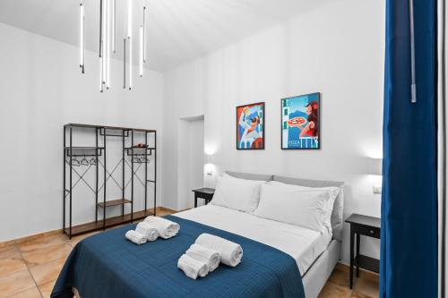 a white bedroom with two towels on a bed at Pangea Stabia Rooms in Castellammare di Stabia