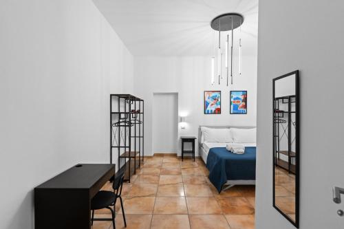 a room with a bed and a table and chairs at Pangea Stabia Rooms in Castellammare di Stabia