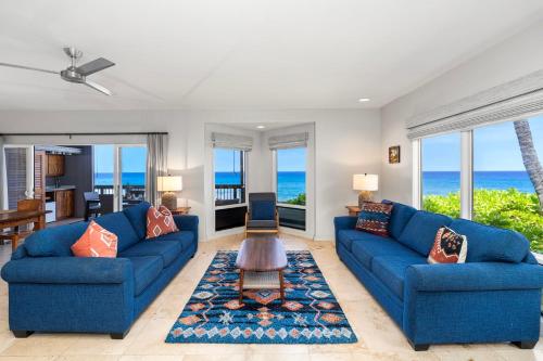 a living room with blue couches and the ocean at Kanaloa at Keauhou 2002 in Kailua-Kona