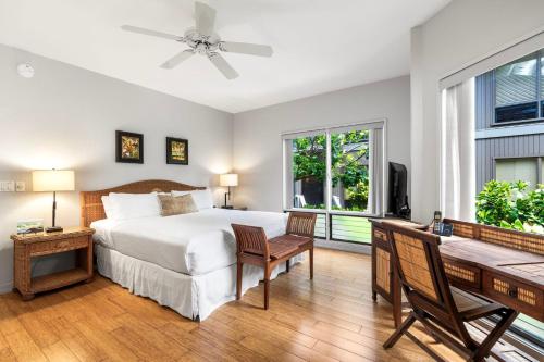 a bedroom with a bed and a desk and a window at Kanaloa at Keauhou 2002 in Kailua-Kona