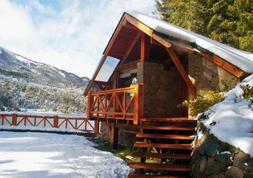 a log cabin in the snow with a staircase at Costa Serena Aparts & Spa in Villa La Angostura