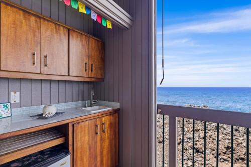a kitchen with a view of the ocean from a balcony at Kanaloa at Keauhou 2002 in Kailua-Kona