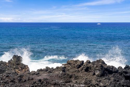 a view of the ocean with a boat in the distance at Kanaloa at Keauhou 2002 in Kailua-Kona