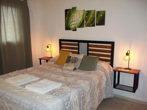 a bedroom with a large bed with two lamps at EVA Apartments 3 in San Rafael