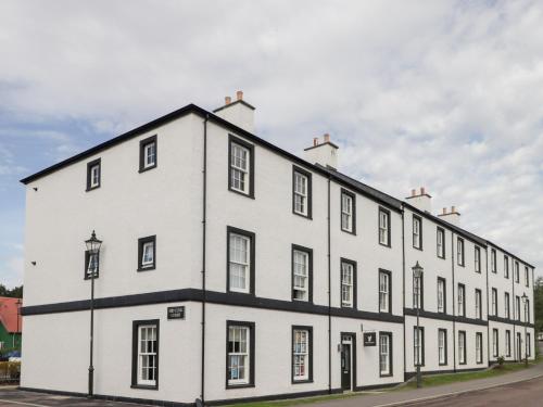 a white building with black windows on a street at The Nook in Inverness