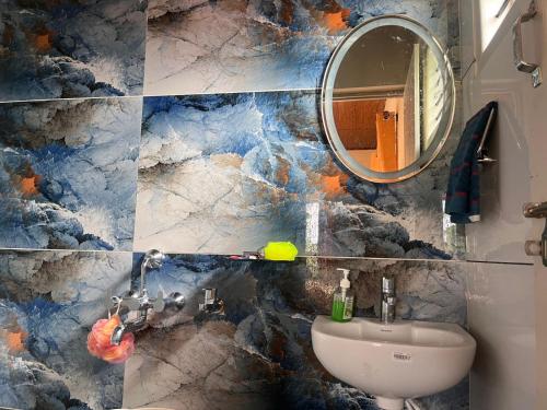 a bathroom with a sink and a mirror at Siri Kuteera Homestay in Vastāra