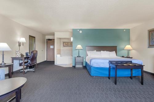 a hotel room with a bed and a desk at AmericInn by Wyndham Green Bay East in Green Bay