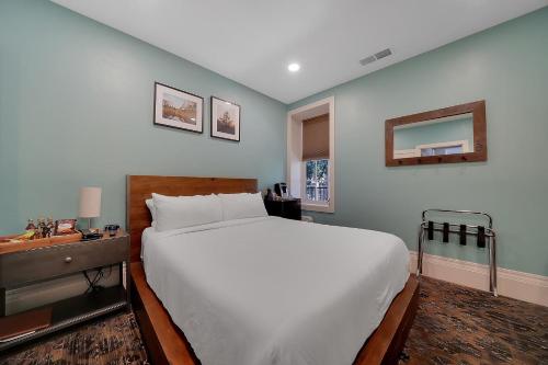 a bedroom with a large white bed and a desk at The Groveland Hotel in Groveland