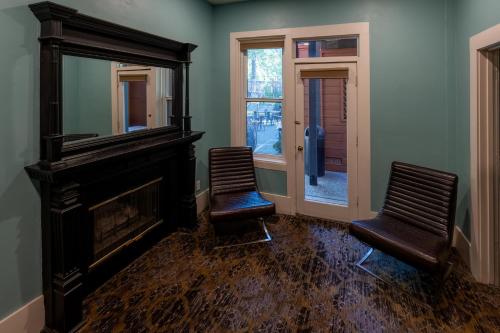 two chairs in a room with a mirror and a fireplace at The Groveland Hotel in Groveland