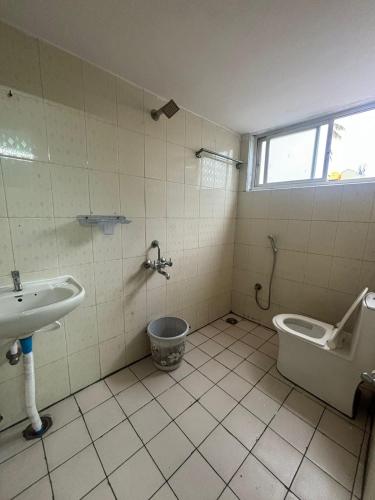 a bathroom with a toilet and a sink at Formula1 Homestay in Mysore