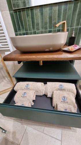 Una mesa con toallas en un estante con un lavabo. en Maredì Brindisi vacation home, en Brindisi