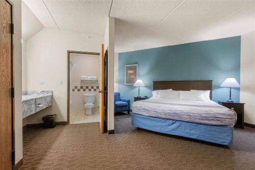 a hotel room with a bed and a bathroom at AmericInn by Wyndham Green Bay East in Green Bay