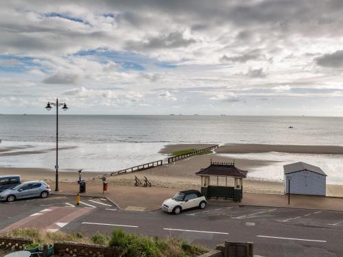 a parking lot next to a beach with a white car at Lower Chine Apartment in Shanklin