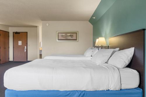 a large white bed in a hotel room at AmericInn by Wyndham Green Bay East in Green Bay