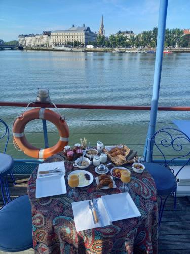 ein Tisch auf einem Boot mit Essen darauf in der Unterkunft Péniche UHARTEA chambre d'hôtes "Baionako Gambara" in Bayonne