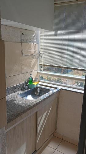 a kitchen counter with a sink and a window at Flat 8A confortável e completo próximo ao Hot Park e Pousada do Rio Quente in Rio Quente