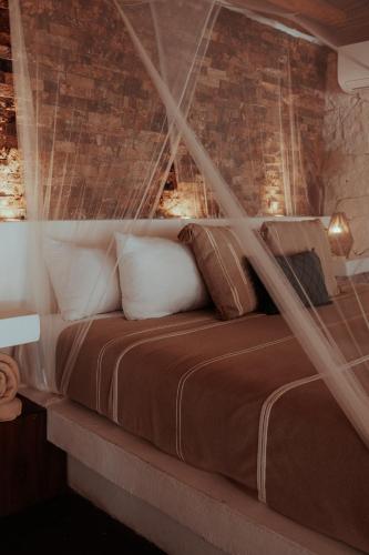 a bedroom with a bed with a mosquito net at Niken Beachfront Tulum Hotel in Tulum