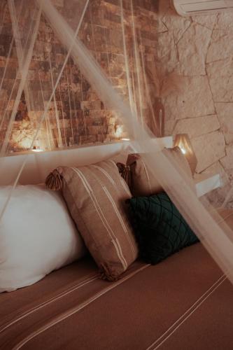 a bed with pillows in a room with a brick wall at Niken Beachfront Tulum Hotel in Tulum