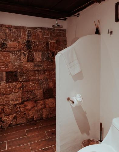 a bathroom with a brick wall and a toilet paper dispenser at Niken Beachfront Tulum Hotel in Tulum
