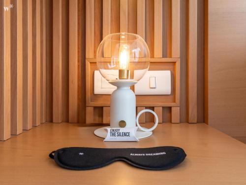 a light with a candle on top of a table at Nuo by Wynwood House in Bogotá