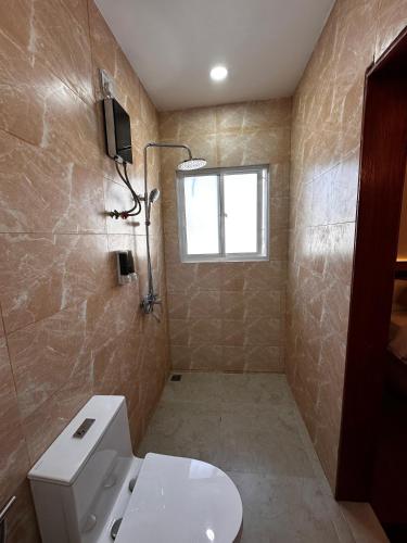 a bathroom with a toilet and a window at Coco Ukulhas Villa in Ukulhas