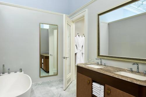 a bathroom with two sinks and a large mirror at Palace Hotel, a Luxury Collection Hotel, San Francisco in San Francisco