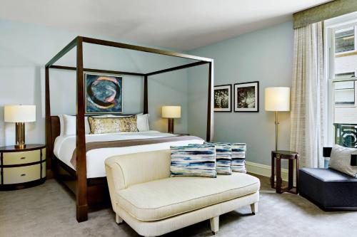 a bedroom with a large bed and a chair at Palace Hotel, a Luxury Collection Hotel, San Francisco in San Francisco
