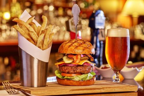 a hamburger and french fries and a glass of beer at Palace Hotel, a Luxury Collection Hotel, San Francisco in San Francisco
