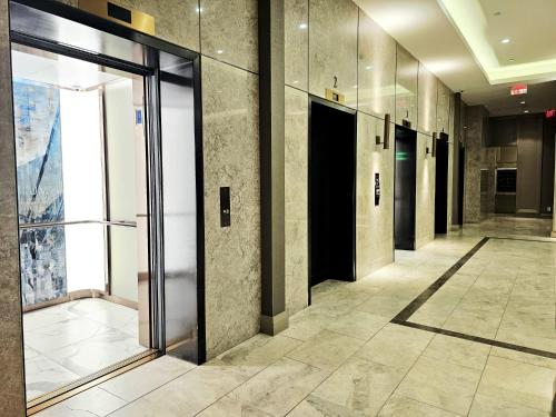 an empty hallway with glass doors in a building at Elegant 2BR & 2BA Retreat in Prime Yorkville, Downtown in Toronto