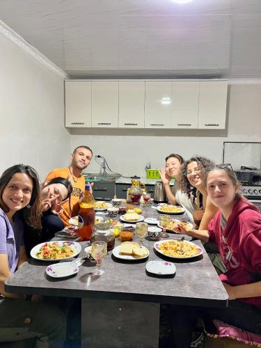 a group of people sitting around a table eating food at October Guesthouse in Jalal-Abad