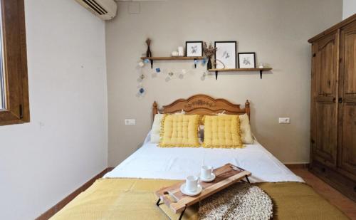 a bedroom with a bed with a wooden headboard and yellow pillows at Campus el abuelo in Denia