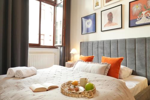 Un dormitorio con una cama con una bandeja de fruta encima. en Pop Art 2BR Bold & Bright Escape Inside Gozsdu, en Budapest