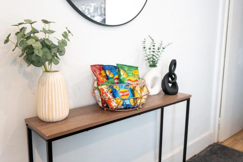 a console table with a vase and a mirror at Modern Cozy Flat with Great Location in Bletchley