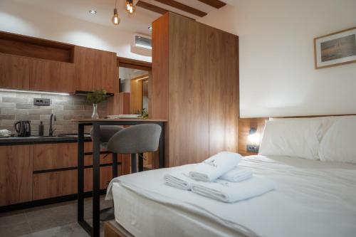 a bedroom with a bed and a desk and a kitchen at Angelina Apart Hotel&Spa in Divčibare