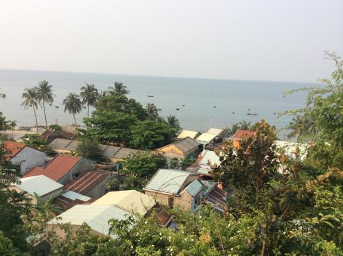 a town with houses and the ocean in the background at Cham Island Smiles Homestay in Tân Hiệp