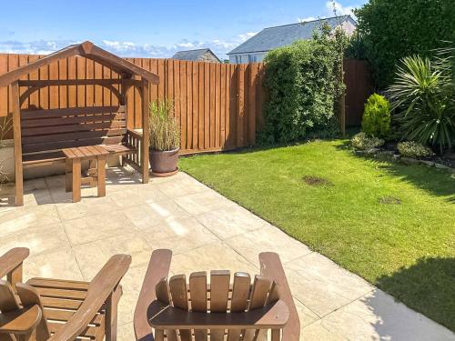 a backyard with a wooden bench and a picnic table at Blissful Ocean Breeze in Perranporth