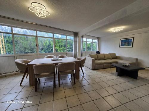 a living room with a table and chairs and a couch at Amplio apartamento sobre Avenida Viaducto in Mexico City