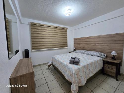 a bedroom with a bed with a wooden head board at Amplio apartamento sobre Avenida Viaducto in Mexico City