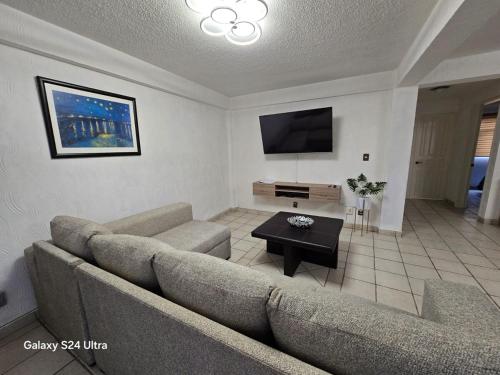 a living room with a couch and a tv at Amplio apartamento sobre Avenida Viaducto in Mexico City