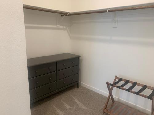 a bedroom with a wooden dresser and a chair at Walking on Water Street in Las Vegas