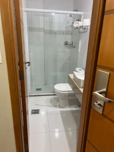 a bathroom with a toilet and a glass shower at STOP Mar Suite Privada - NI in Nova Iguaçu