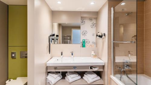 アンネヴィルにあるGolden Tulip Amnéville - Hôtel Spa & Casinoの洗面台とシャワー付きのバスルーム