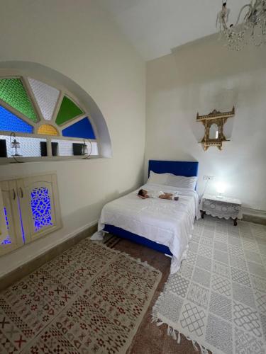 a bedroom with a white bed and a window at BALKIS La RÊNE DE SABA in Sidi Bou Saïd