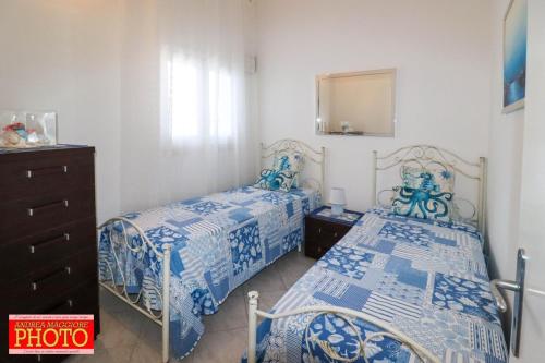 a bedroom with two beds and a dresser and a mirror at Villetta Blu in Capilungo
